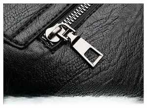 Close-up of premium gunmetal zipper on high-quality black lychee texture PU leather bag