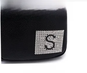 Close-up of black litchi grain leather bag featuring a sparkling rhinestone S logo plate