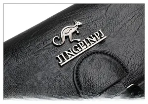 Macro shot of black litchi pattern PU leather with silver metal kangaroo brand logo detail