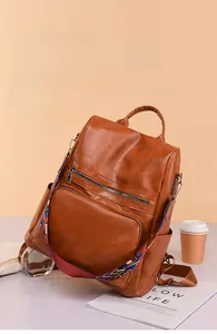 Detail view of brown PU leather backpack with vintage texture and ethnic style strap
