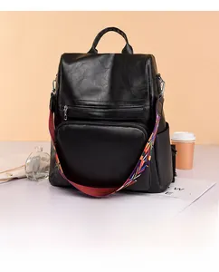 Detailed view of black PU leather backpack with a colorful ethnic style woven strap