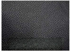 Close-up of black litchi grain PU leather with dense texture and soft oily finish