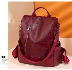 Detail of dark red faux leather backpack with geometric embossed pattern and zipper