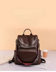 Detail view of brown PU leather backpack with colorful bohemian woven wide shoulder strap