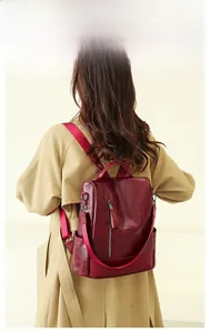 Detail view of large dark red PU leather backpack with vintage texture and zipper design
