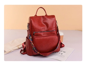Detailed view of deep red PU leather backpack with colorful bohemian shoulder strap