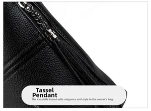 Detail of black pebbled leather crossbody bag with gunmetal zipper and long tassel pendant
