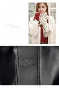 Detail of black pebbled leather texture with embossed kangaroo logo and brand lettering