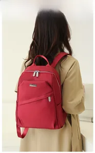 Sac à dos en tissu Oxford rouge foncé porté par un mannequin pour voyage et école
