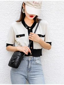 Detail of black crossbody bag featuring pebbled texture and functional zipper pockets