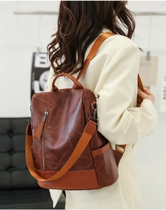 Detailed back view of brown PU leather backpack with geometric texture on model