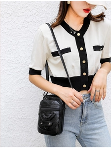 Close-up of soft black PU leather crossbody bag with double zippers and metal rivets