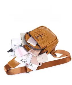 Detail view of large capacity vintage PU leather chest bag holding an iPad mini and phones
