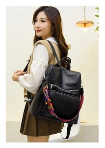 Detail of black PU leather backpack with a colorful geometric woven shoulder strap