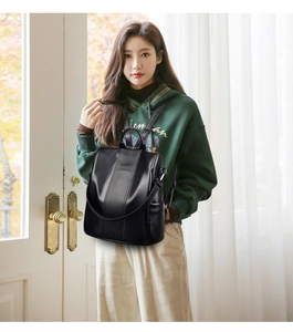 Detailed view of women black leather backpack with flap and zipper anti-theft design