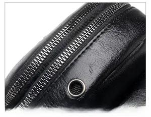 Detail of smooth silver zipper and lychee grain black PU leather texture on crossbody bag