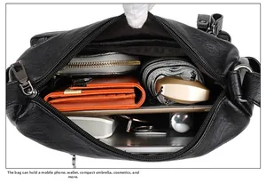 Interno spazioso della borsa a tracolla in pelle nera che mostra la capacità per i gadget