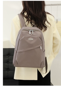 Sac à dos moderne en tissu Oxford taupe porté par un mannequin pour voyage urbain chic