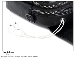 Detail of black pebbled leather crossbody bag featuring dual zippers and headphone port