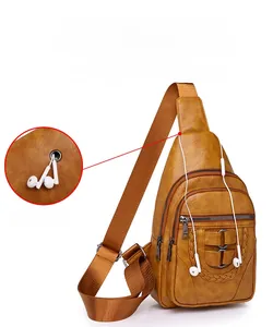 Detail of brown PU leather chest bag with an external headphone port and zippers