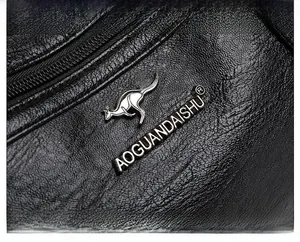 Dettaglio della trama in pelle PU nera con logo a canguro argentato e incisione