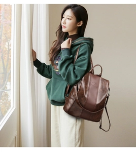 Detail of vintage brown PU leather backpack featuring kangaroo logo and metal zipper