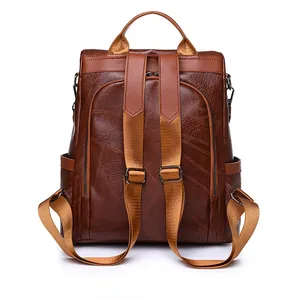 Back view of brown PU leather anti-theft backpack showing zip entry and wide straps