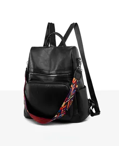Detail view of black PU leather backpack with a colorful ethnic style woven shoulder strap