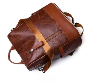 Detail view of brown faux leather backpack with geometric texture and metal zippers