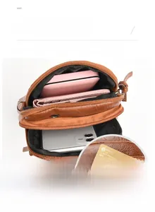 Detail of soft brown PU leather crossbody bag showing interior capacity and front zip pocket