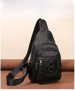 Close-up of black PU leather chest bag featuring woven strap details and metal rings