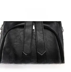 Close-up of black PU leather backpack with sturdy metal zipper and reinforced stitching