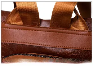 Macro view of reinforced stitching on brown PU leather backpack handle and texture