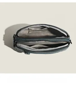 Detail view of the multi-layer interior compartments in grainy dark teal leather bag