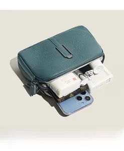 Macro shot of leather crossbody bag showing inner storage capacity for daily essentials