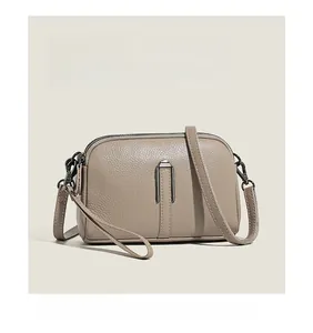 Close-up of khaki leather handbag with litchi texture and silver U-shaped metal buckle