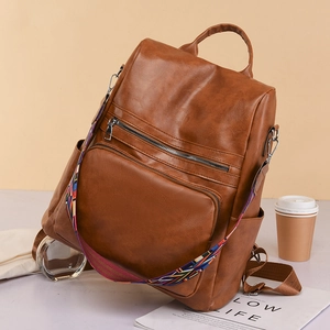 Retro brown PU leather backpack with large capacity and ethnic woven strap for travel