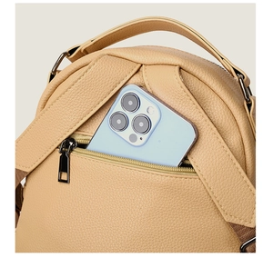 Detail of lychee textured leather backpack featuring a functional front zipper pocket