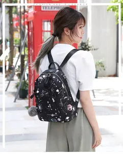 Sac à dos en tissu Oxford avec imprimé spatial et pompon montré sur modèle