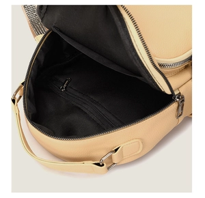 Internal view of cream PU leather backpack showing black lining and zip pocket