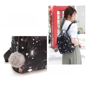 Détail du sac à dos en oxford à motif galaxie avec un porte-clé pompon gris pelucheux