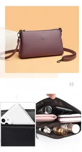Detail view of purple leather crossbody bag with multiple interior pockets for storage