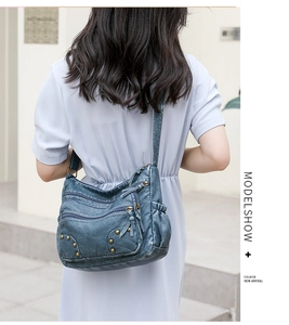 Detail of vintage blue washed faux leather crossbody bag with studs and multi-pocket design