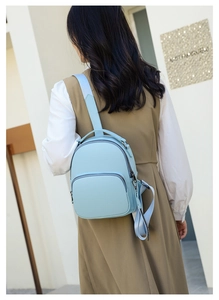 Close-up of light blue pebbled leather backpack showing texture and metal zipper