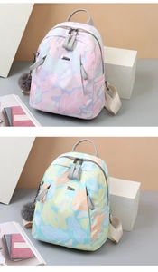 Détail de sacs à dos en tissu Oxford avec imprimé floral et pendentifs en peluche