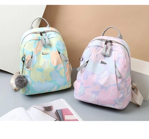 Détail du sac à dos en oxford à imprimé floral avec pompon et accents gris doux