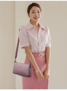 Detail of mauve faux leather crossbody bag with silver logo and pebble grain texture