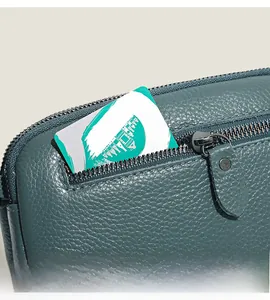 Detail of teal pebble grain leather texture and side zipper pocket on a handbag