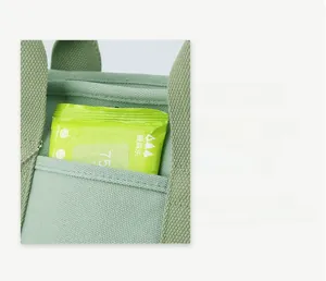 Close-up of canvas handbag front pocket showing storage capacity for wet wipes
