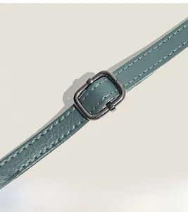 Detailed close-up of dark green lychee grain leather shoulder strap with sturdy stitching